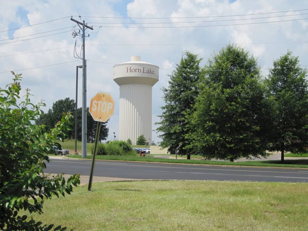 Horn Lake, MS water tower with surrounding greenery and trees, representing the city's well-maintained landscapes. Professional lawn care services available in Horn Lake and the Mid-South region.