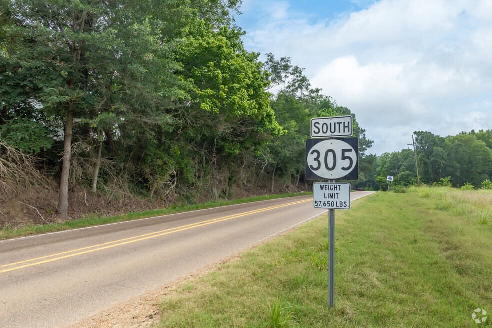 Scenic rural road along Highway 305 in Lewisburg, MS, featuring lush greenery and open landscapes. Expert lawn care services available in Lewisburg and surrounding Mid-South areas.