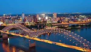 Stunning night view of the Memphis, TN skyline featuring the illuminated Hernando de Soto Bridge over the Mississippi River. Professional lawn care services available in Memphis and surrounding Mid-South areas.
