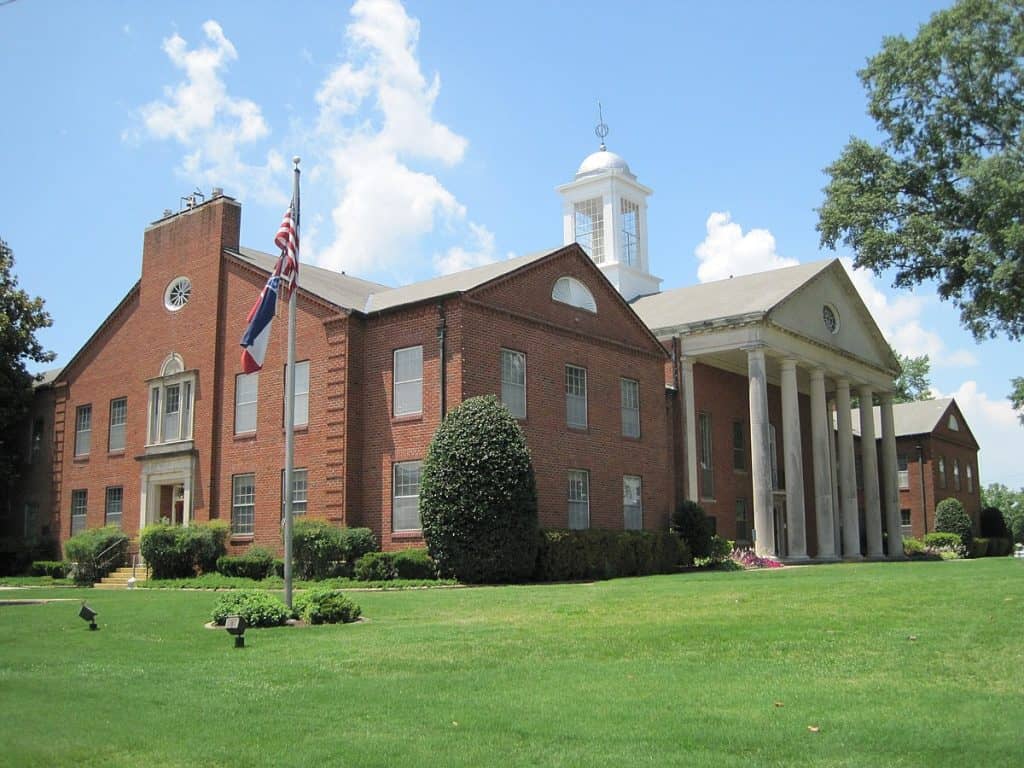 Historic courthouse in Nesbit, MS, surrounded by lush green landscaping and a well-maintained lawn. Professional lawn care services available in Nesbit and surrounding Mid-South areas.