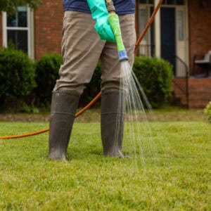 Technician performing post-emergent weed control spot treatment with a spray nozzle in North Mississippi